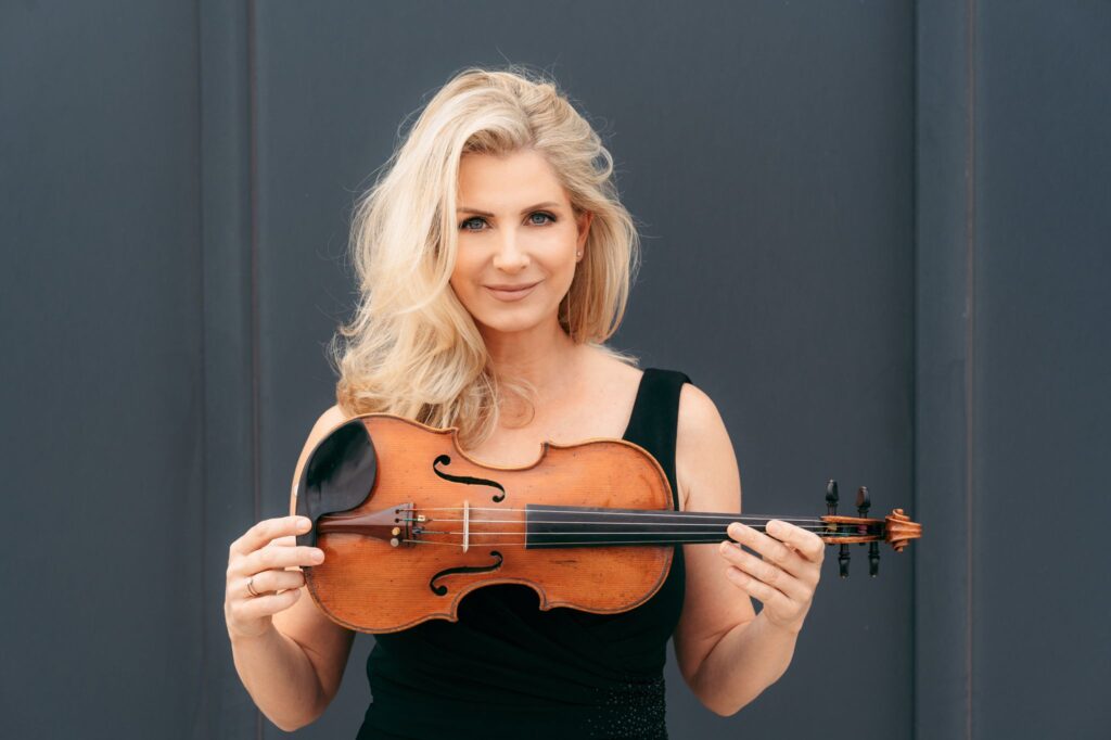 A Blond Woman Holding a Violin