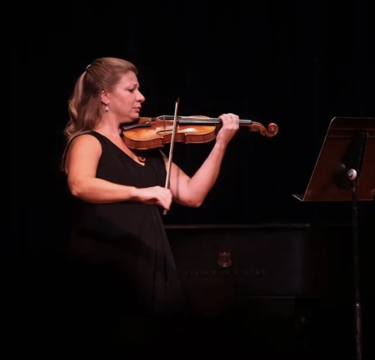 A Woman in Black Playing a Violin