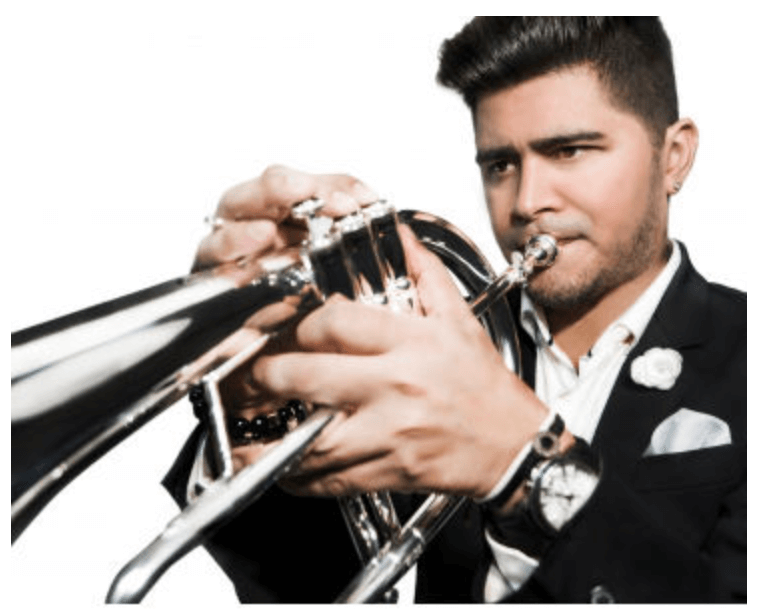 A person blowing a trumpet wearing a suit