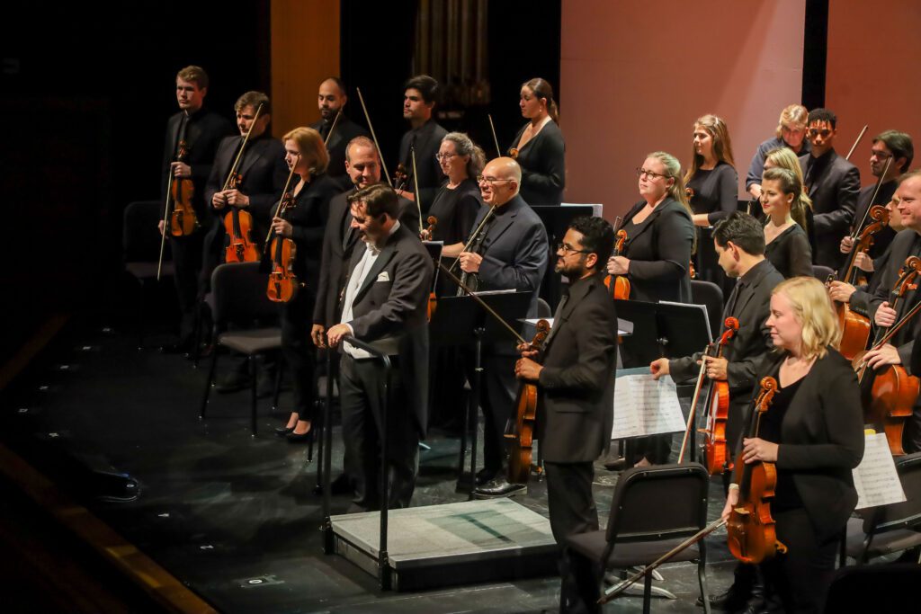 All the musicians standing and smiling