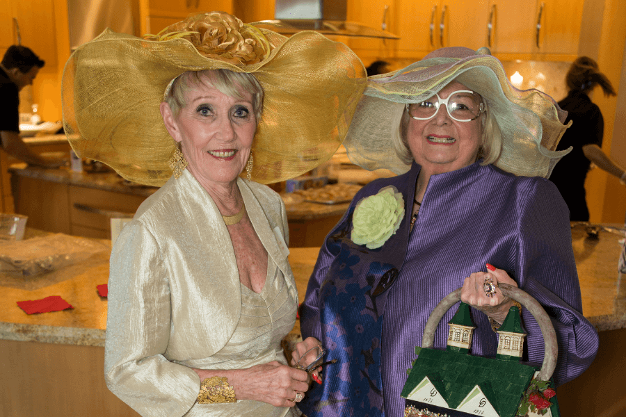 Two elderly women wearing hats and posing